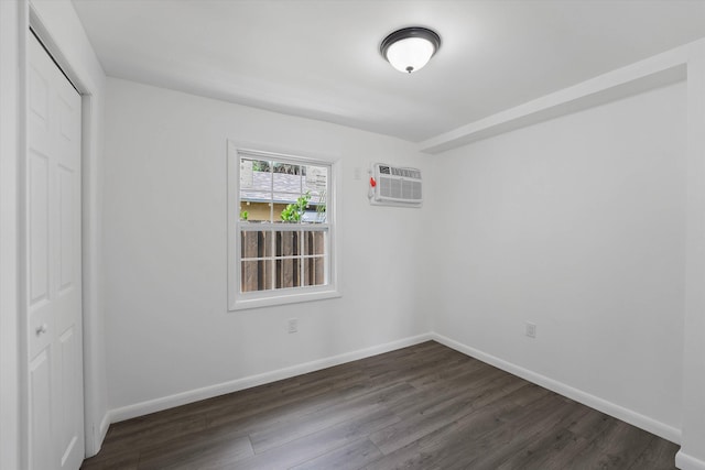 unfurnished room featuring dark hardwood / wood-style flooring and a wall mounted AC