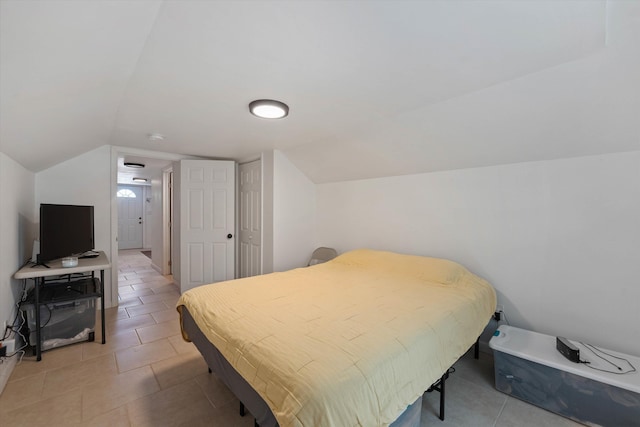 tiled bedroom featuring lofted ceiling