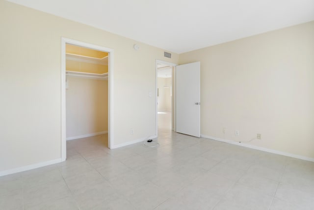 unfurnished bedroom with a closet, light tile patterned floors, and a spacious closet