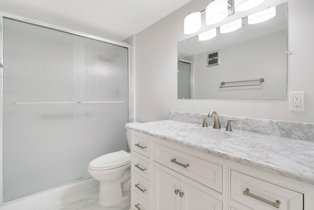 bathroom featuring vanity, toilet, and a shower with shower door