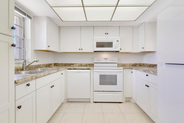 kitchen with white cabinets, white appliances, light tile patterned floors, and sink