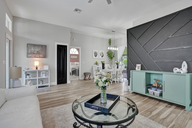 living room featuring ceiling fan, plenty of natural light, and light hardwood / wood-style floors