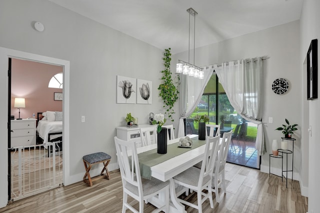 dining space featuring light hardwood / wood-style flooring and a notable chandelier