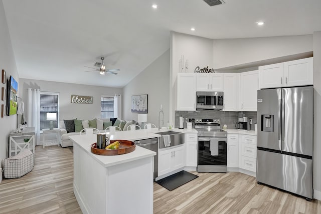 kitchen with sink, stainless steel appliances, kitchen peninsula, and white cabinets