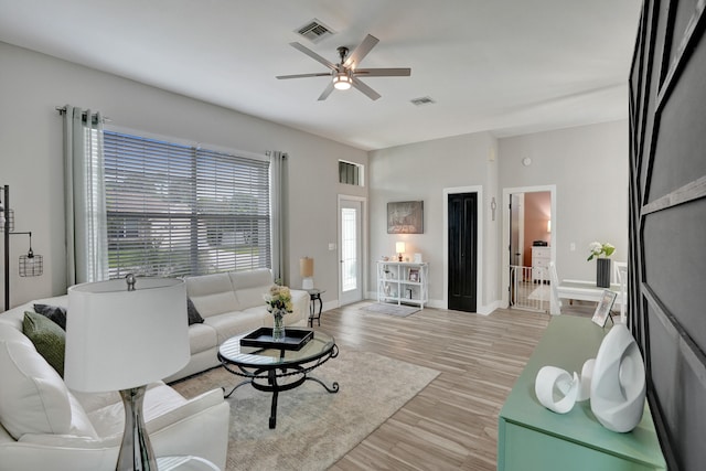 living room featuring ceiling fan and light hardwood / wood-style flooring