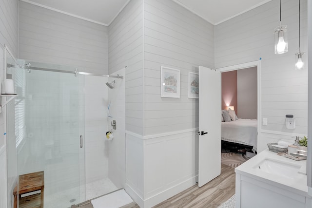 bathroom featuring a shower with door, crown molding, hardwood / wood-style flooring, and vanity