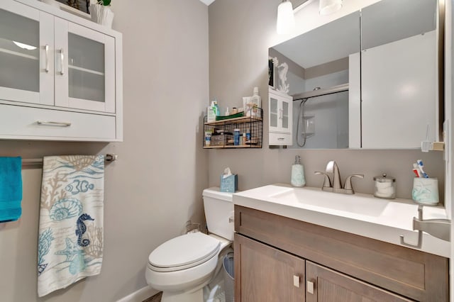 bathroom with vanity, toilet, and a shower with door