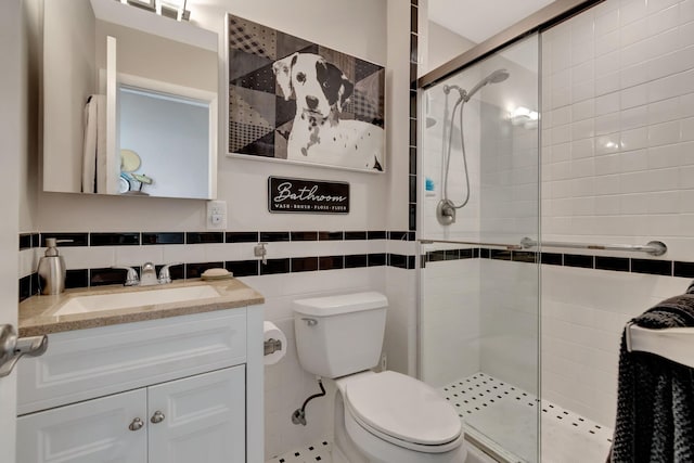 bathroom featuring vanity, tile walls, toilet, and an enclosed shower