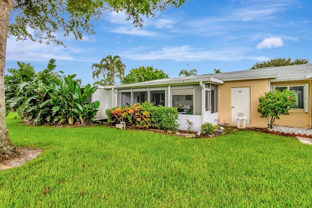 view of front of property featuring a sunroom and a front yard