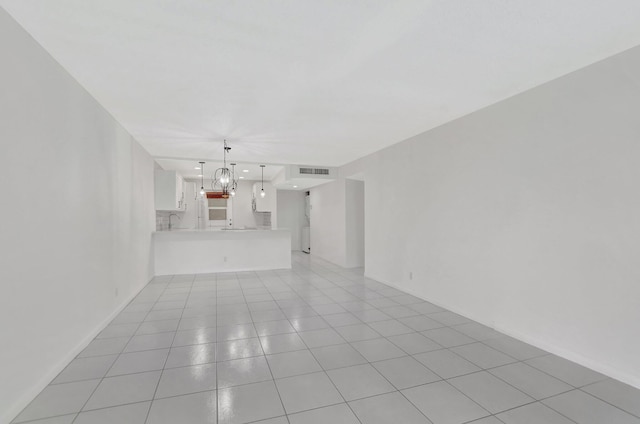 unfurnished living room with light tile patterned floors and a chandelier