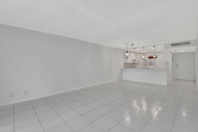 unfurnished living room featuring a notable chandelier and light tile patterned flooring