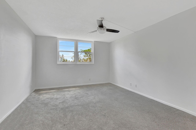 unfurnished room with a textured ceiling, carpet flooring, and ceiling fan