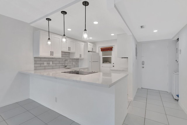 kitchen featuring kitchen peninsula, sink, decorative light fixtures, white cabinetry, and white fridge