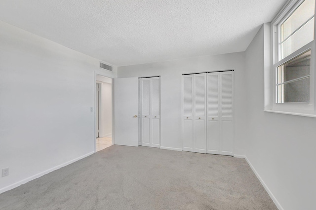 carpeted bedroom featuring a closet and a textured ceiling