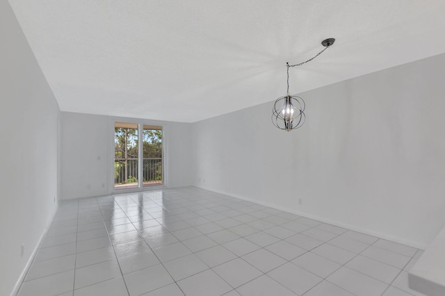 empty room with an inviting chandelier and light tile patterned floors