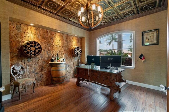 office area featuring coffered ceiling, wood-type flooring, crown molding, and a chandelier