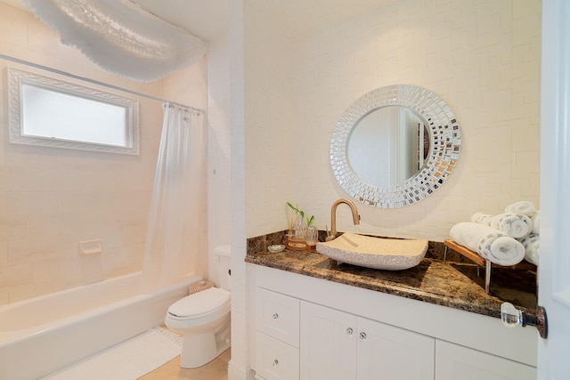 full bathroom featuring tile patterned floors, vanity, toilet, and shower / bath combo with shower curtain