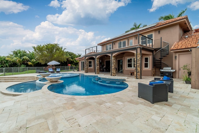 view of pool with an in ground hot tub, a patio area, and a grill