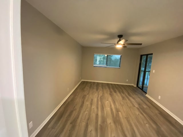 unfurnished room with ceiling fan and dark hardwood / wood-style floors