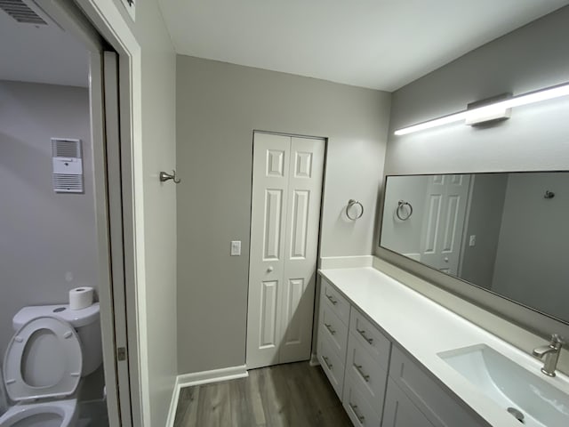 15456 Pembridge Dr Unit 304, Delray Beach, FL 33484 - bathroom featuring toilet, vanity, visible vents, and wood finished floors