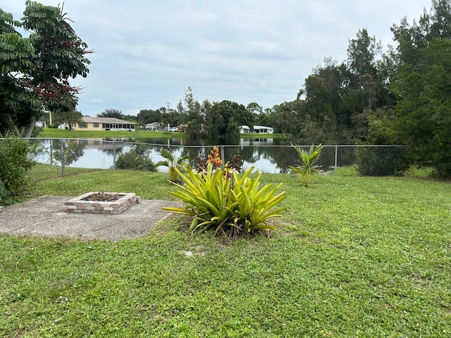 view of yard with a water view and a fire pit