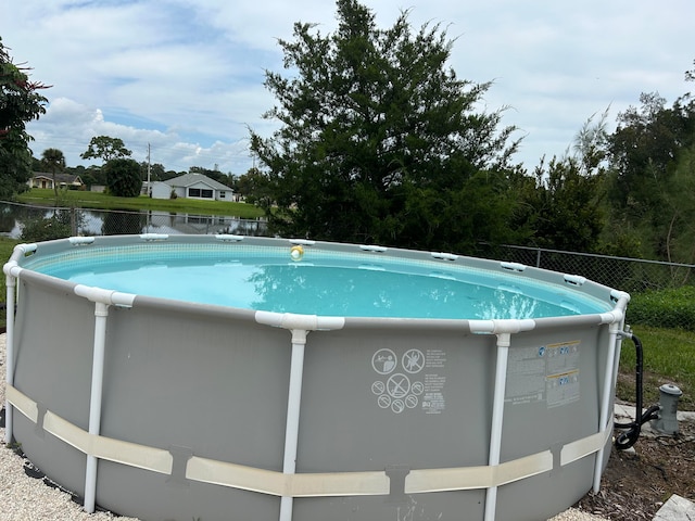 view of swimming pool featuring a water view