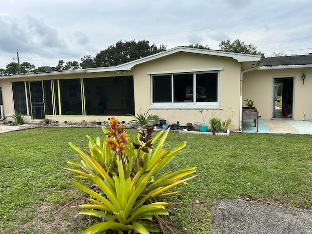 back of house with a yard and a sunroom