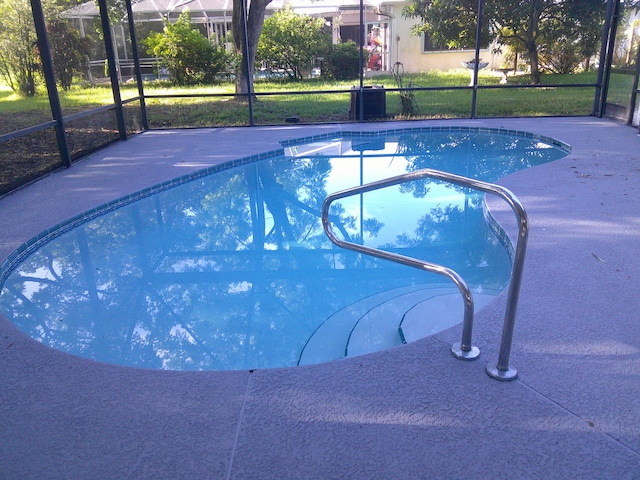 view of pool featuring a lanai and a lawn