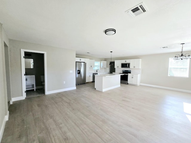 unfurnished living room featuring a notable chandelier, light hardwood / wood-style flooring, and sink