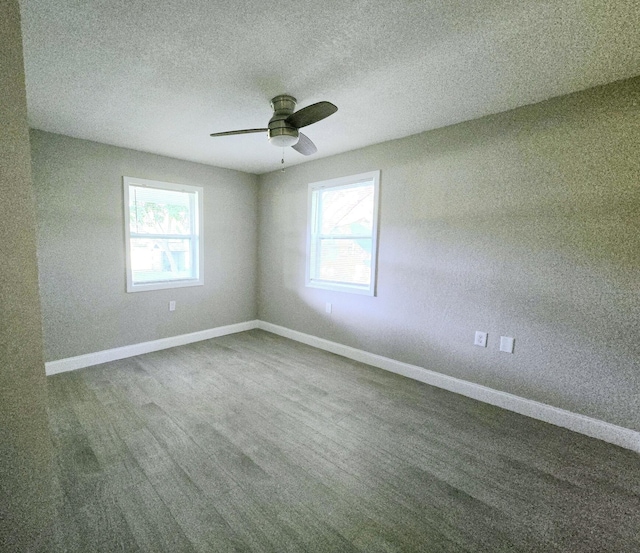 empty room with ceiling fan, carpet floors, a healthy amount of sunlight, and a textured ceiling