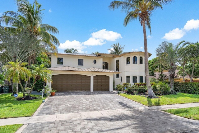 mediterranean / spanish house featuring a front yard and a garage