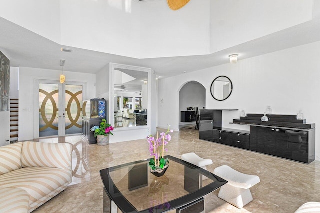 living room with ceiling fan and a towering ceiling