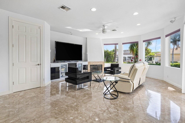 living room with ceiling fan, a textured ceiling, and french doors