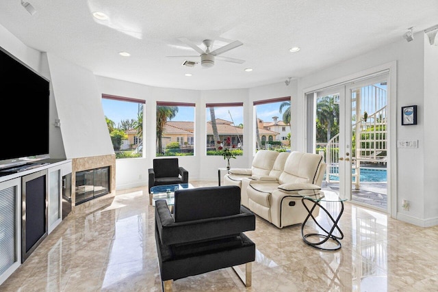 living room featuring ceiling fan and a textured ceiling