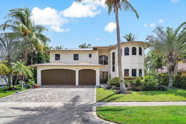 mediterranean / spanish-style house featuring a garage and a front yard