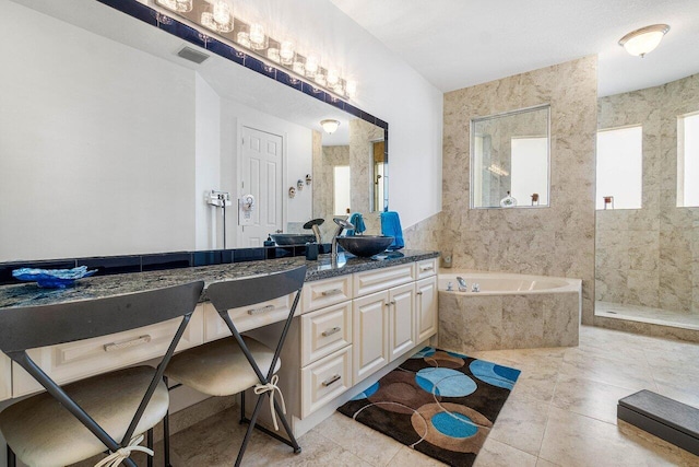 bathroom featuring vanity and tiled bath