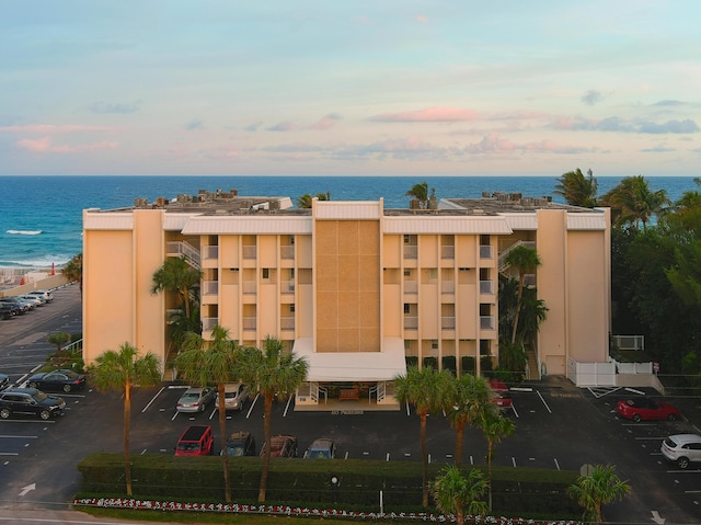 view of building exterior with a water view and uncovered parking