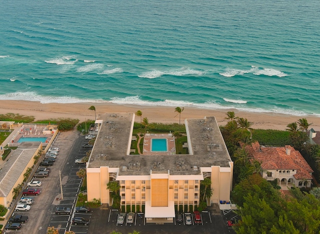 birds eye view of property with a water view and a beach view