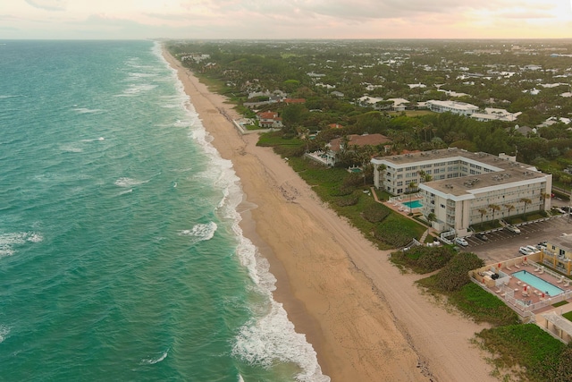 birds eye view of property featuring a beach view and a water view