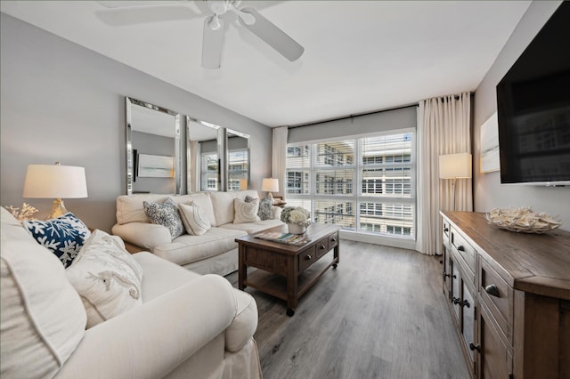 living area with a wealth of natural light, ceiling fan, and wood finished floors