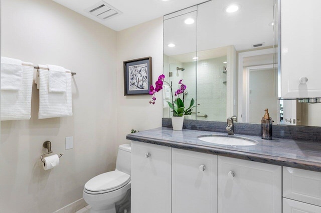 bathroom featuring vanity, toilet, and a shower with door