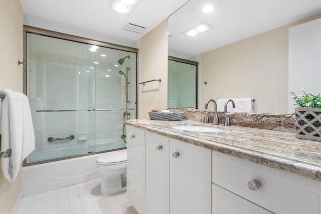 full bathroom featuring vanity, toilet, and combined bath / shower with glass door