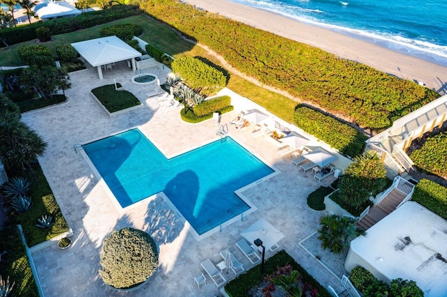 birds eye view of property featuring a water view and a beach view