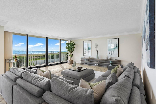 living room featuring a water view, ornamental molding, a textured ceiling, and a wall of windows