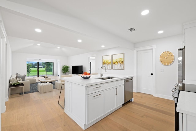 kitchen featuring light wood-type flooring, a kitchen island with sink, range, sink, and white cabinetry