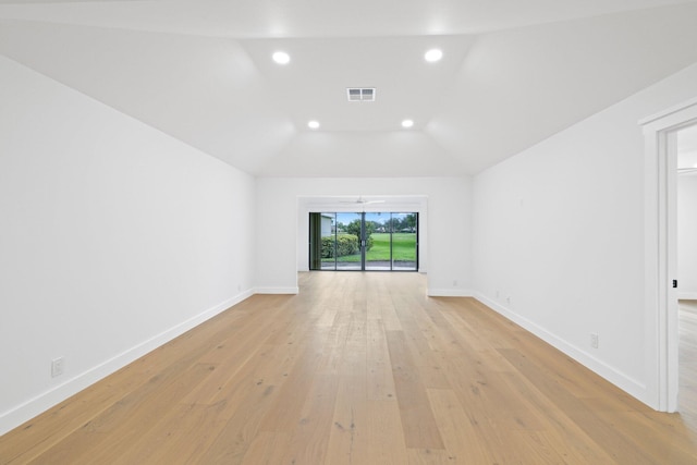 spare room featuring light wood-type flooring and lofted ceiling