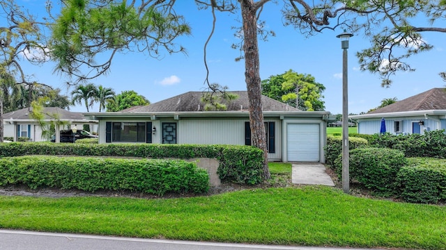 ranch-style home with a garage and a front yard