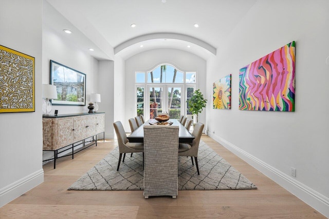 dining area with french doors, light hardwood / wood-style flooring, and vaulted ceiling