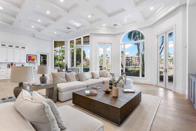 living room with french doors, a towering ceiling, coffered ceiling, and beam ceiling