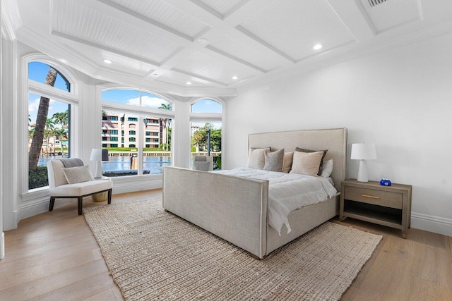 bedroom with beam ceiling, crown molding, light hardwood / wood-style flooring, and coffered ceiling